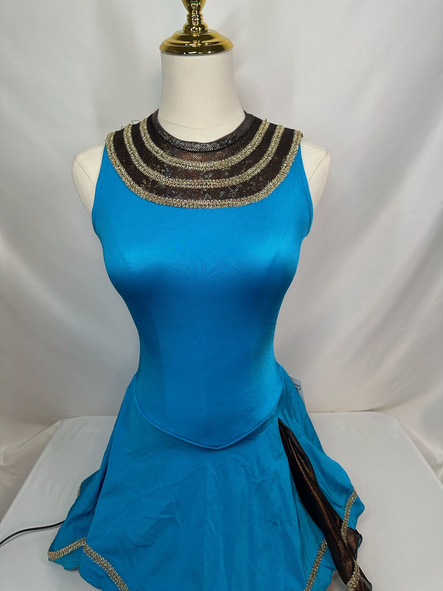 front view of Turquoise Gold Trim Mesh Yoke Figure Skating Dress