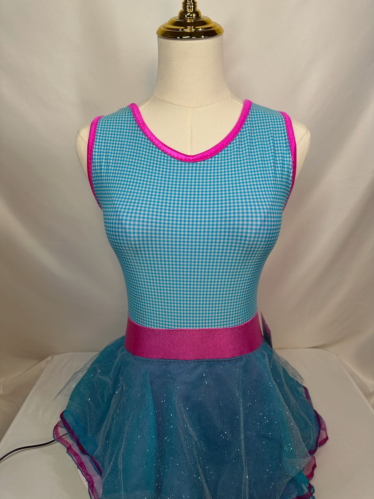 front view of Turquoise Gingham Pink Trim Glitter Tulle Skating Dress