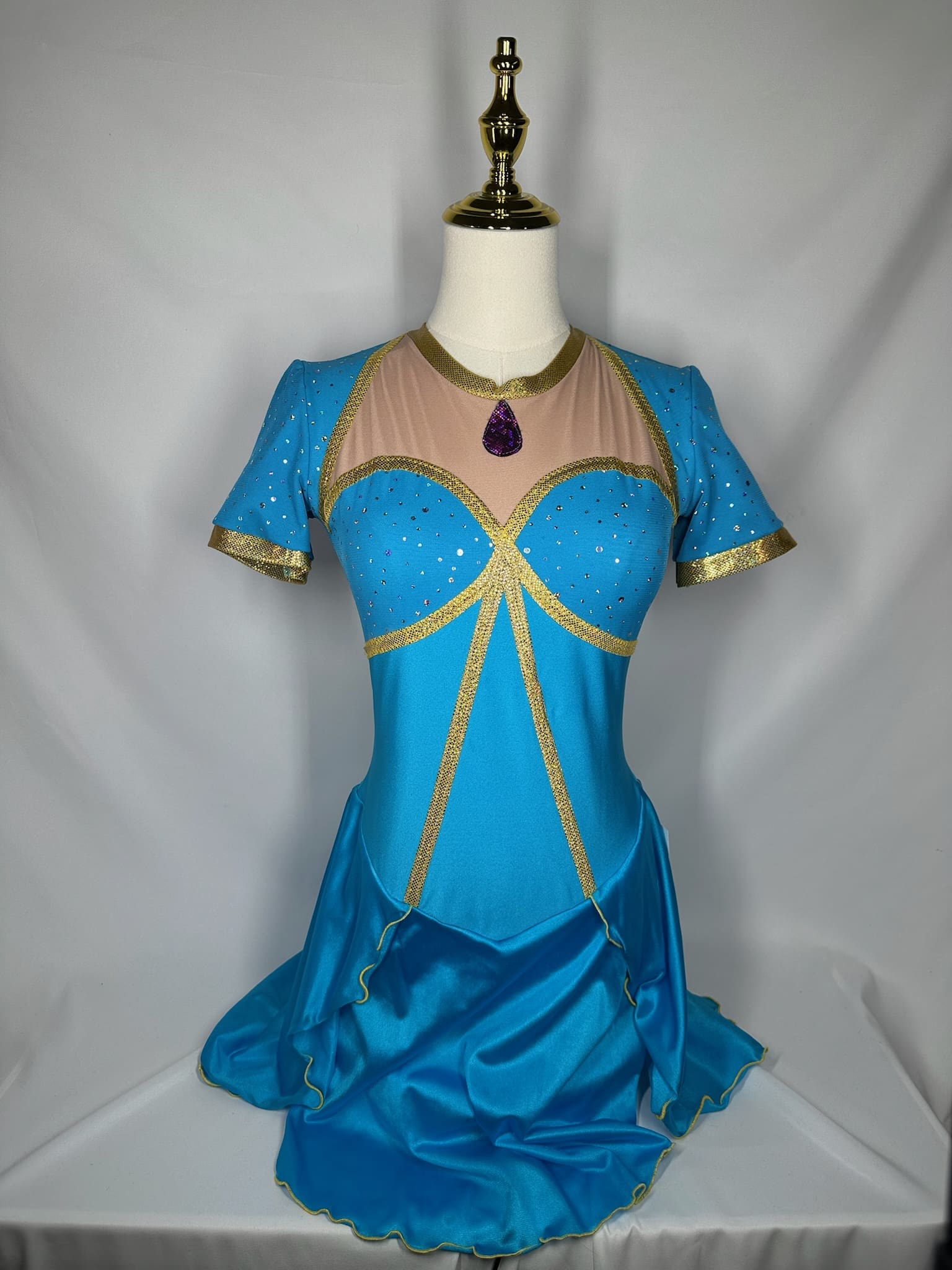 front view of Turquoise Gold Princess-Inspired Figure Skating Dress