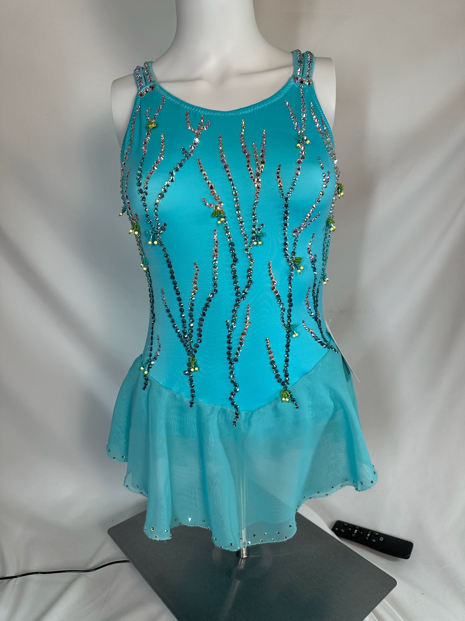 front view of Turquoise Swarovski Cross Back Figure Skating Dress